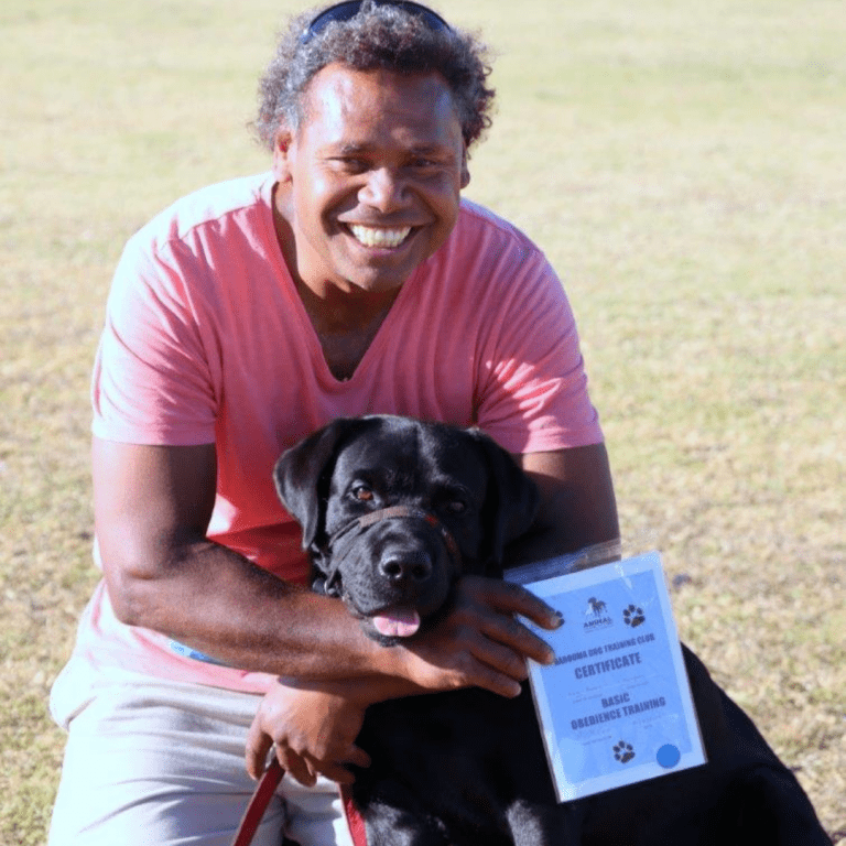 A smiling man hugging his dog